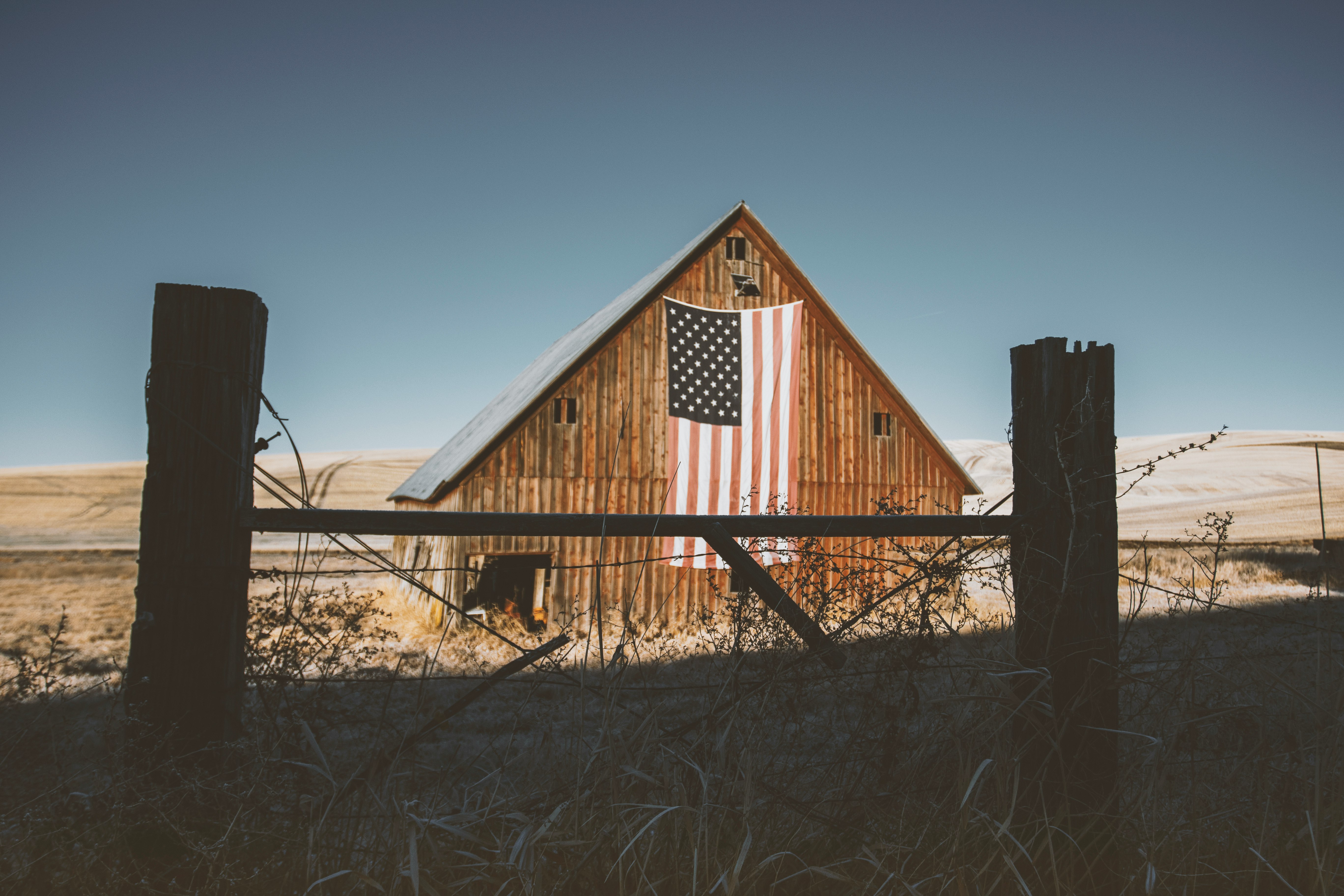 brown wooden house on brown field under blue sky during daytime